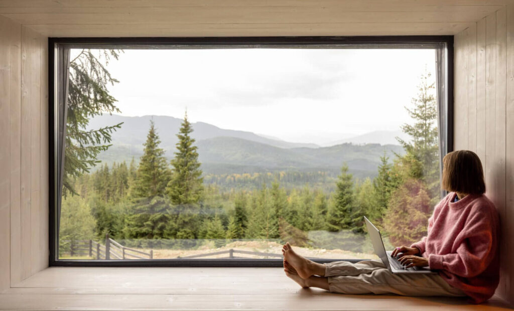 Oversized black vinyl picture window providing panoramic mountain landscape views in modern residential interior