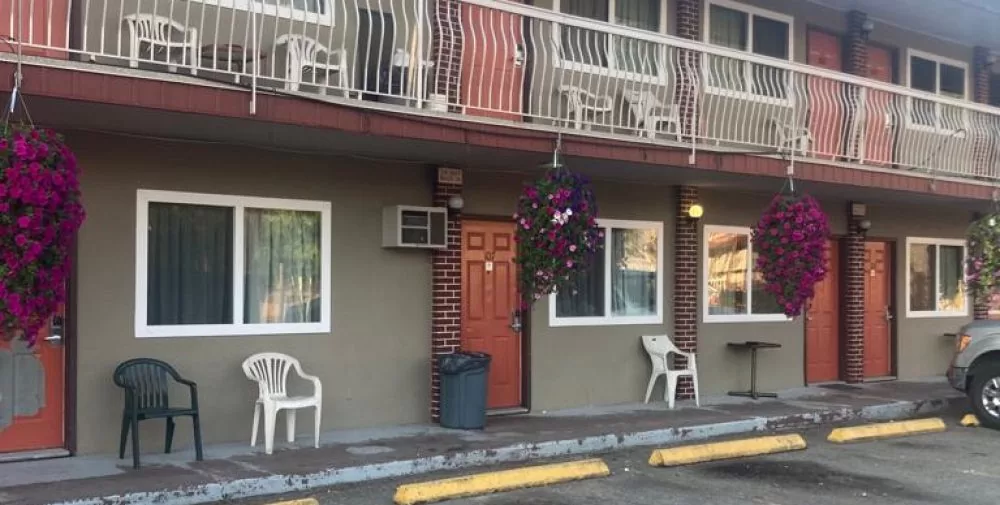 Red brick apartment building with white vinyl replacement windows and patio doors under balcony
